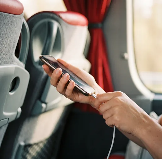 Smartphone lädt an der Steckdose am Sitzplatz