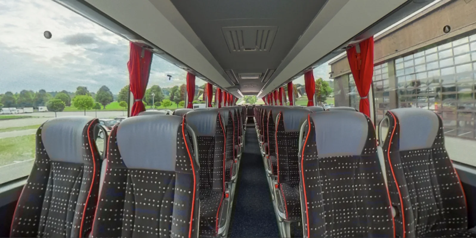 Blick durch den Innenraum des Deluxe-Busses mit Dreierbestuhlung