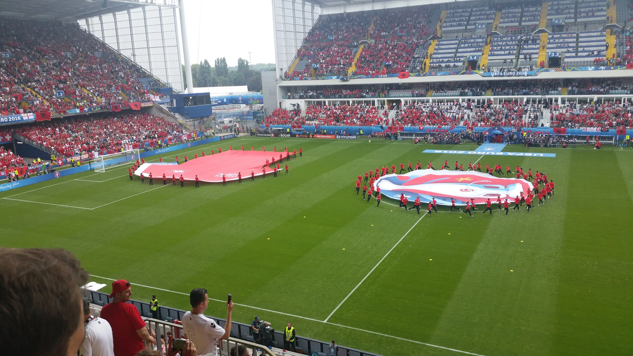 Gigantesca bandiera svizzera e altre bandiere sul prato prima di una partita degli Europei 2016 a Lens