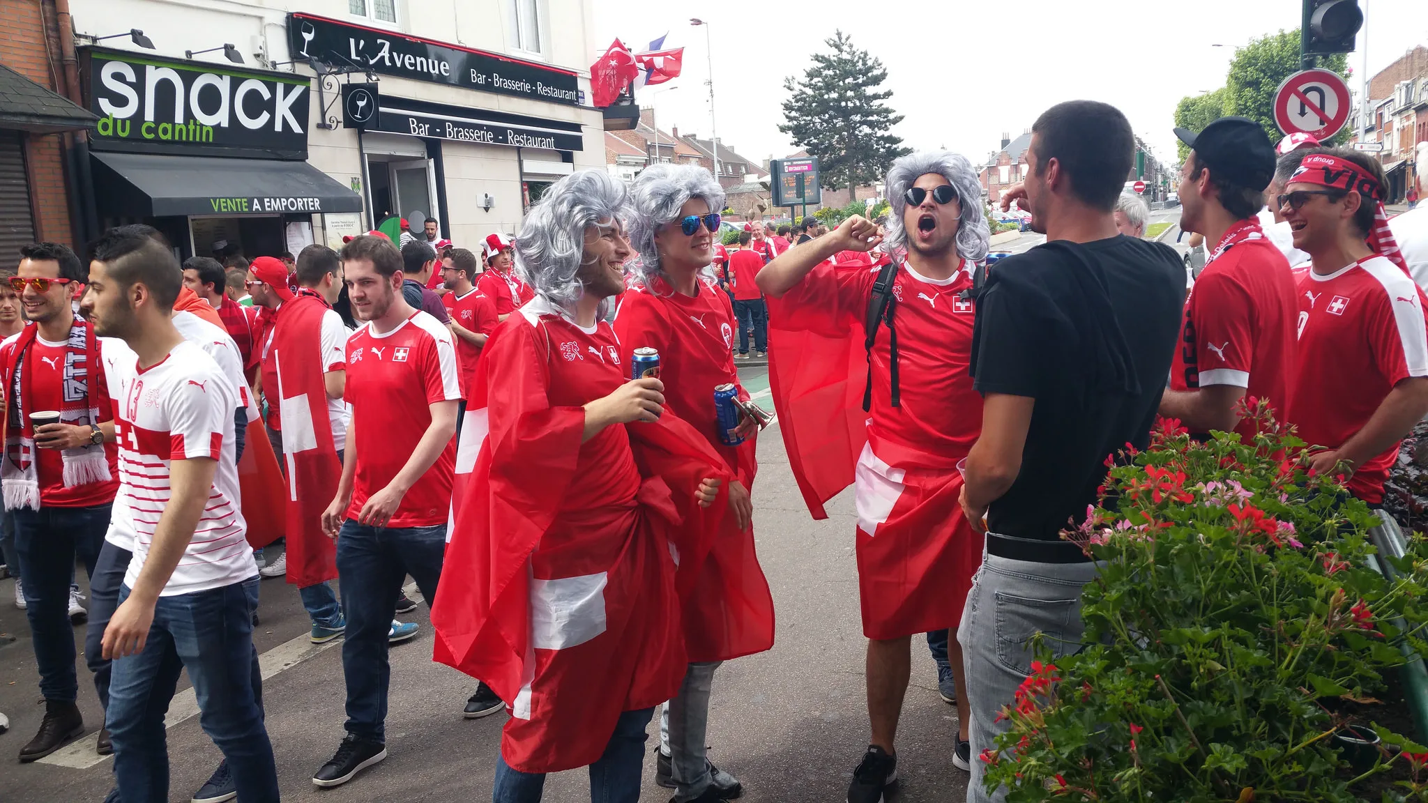 Schweizer Fans mit Fahnen als Umhang und grauen Perücken auf einer Strasse in Lens an der EM 2016