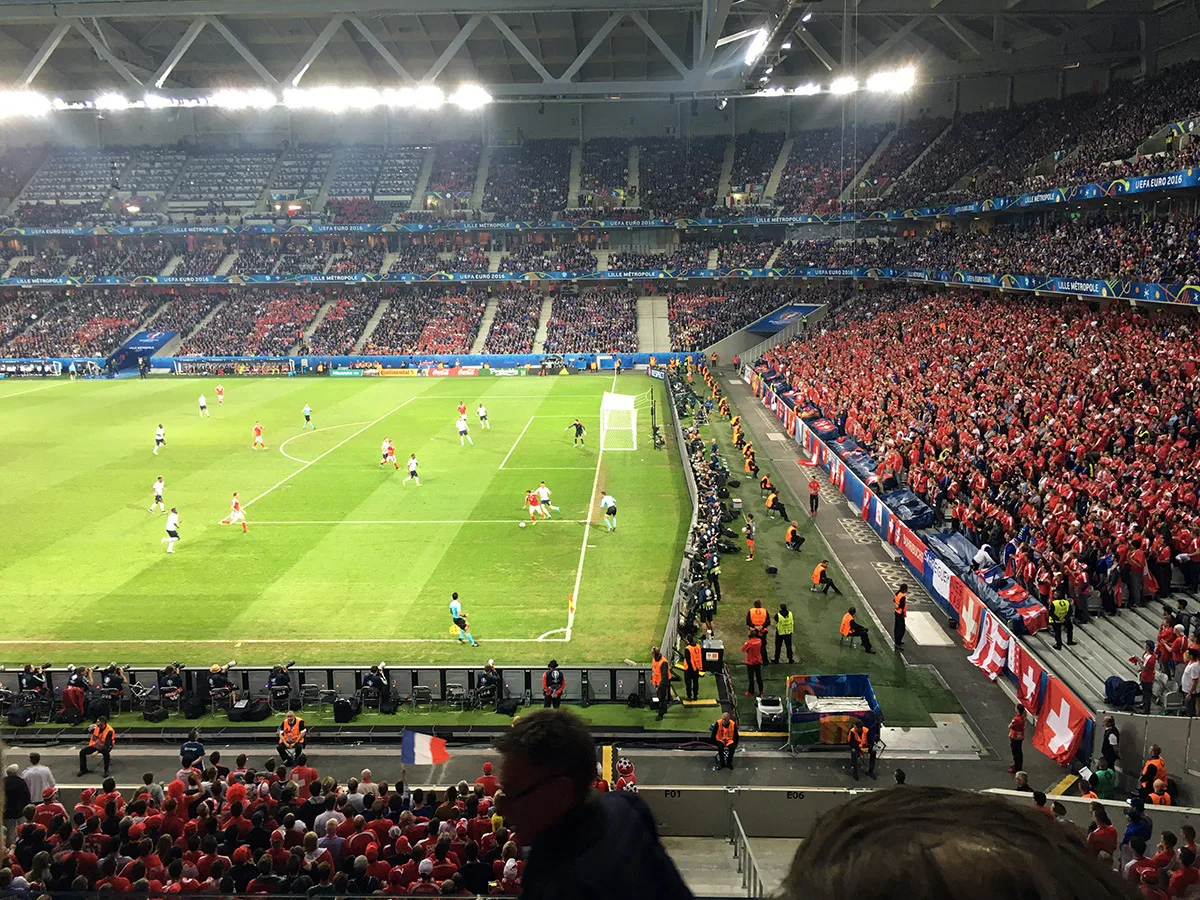 Partita serale sotto i riflettori agli Europei 2016 a Lille, a destra il settore dei tifosi in rosso