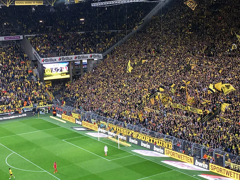 Tribuna sud gialla gremita, con bandiere, al Signal Iduna Park di Dortmund