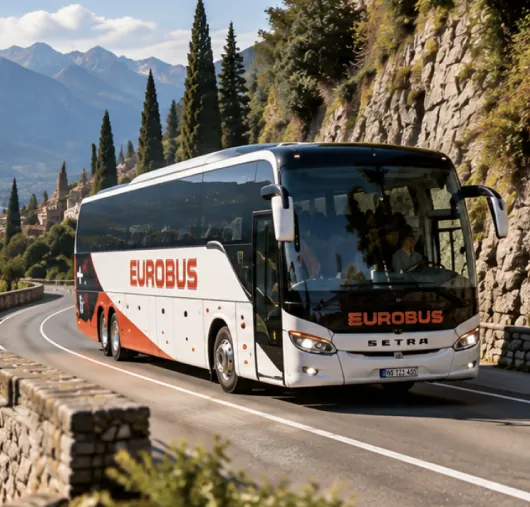 Un autocar EUROBUS roule sur une route de montagne en passant devant des cyprès