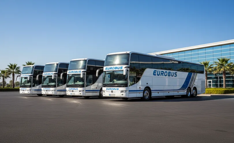 Four coaches parked side by side on a square