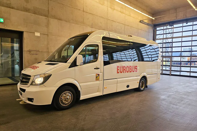 A white EUROBUS minibus parked in a hall