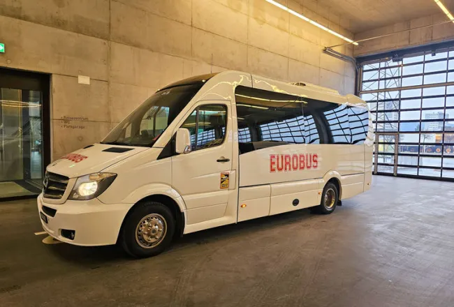 A white EUROBUS minibus parked in a hall
