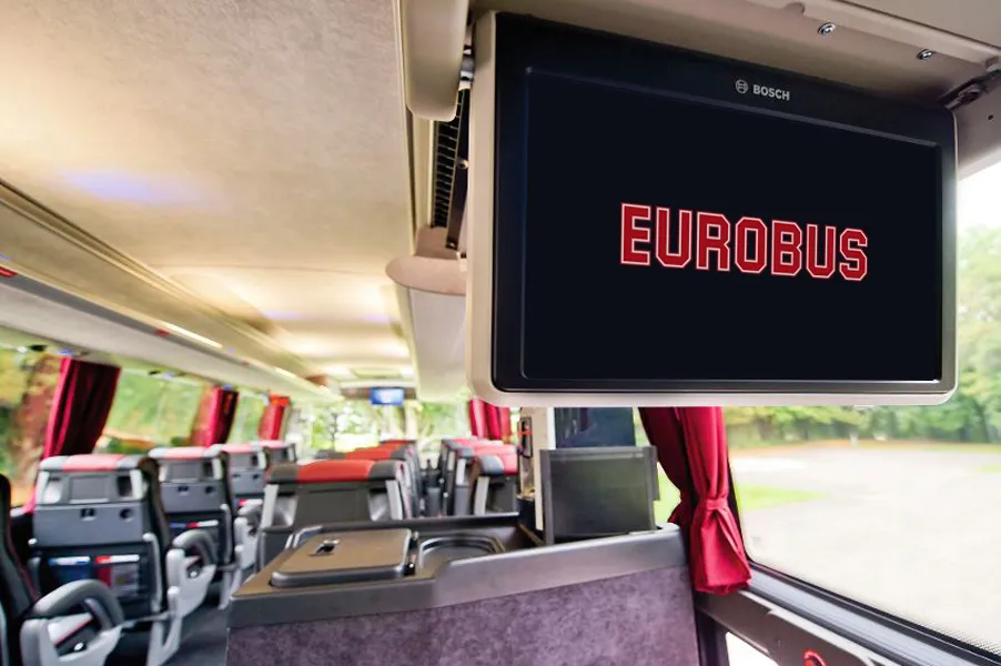 Screen with the EUROBUS logo above the rows of seats in the Deluxe coach