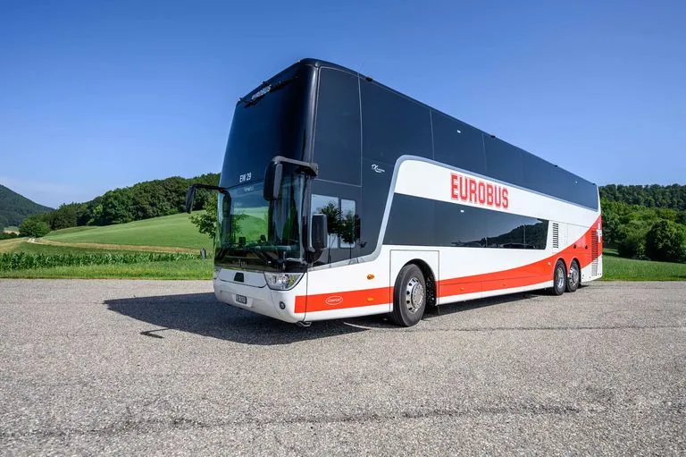 Un car à deux étages EUROBUS stationné sur une place devant une prairie