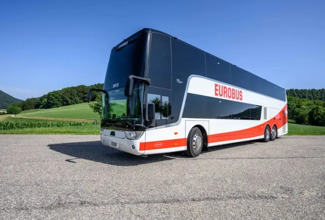 A EUROBUS double-decker parked on a square in front of a meadow