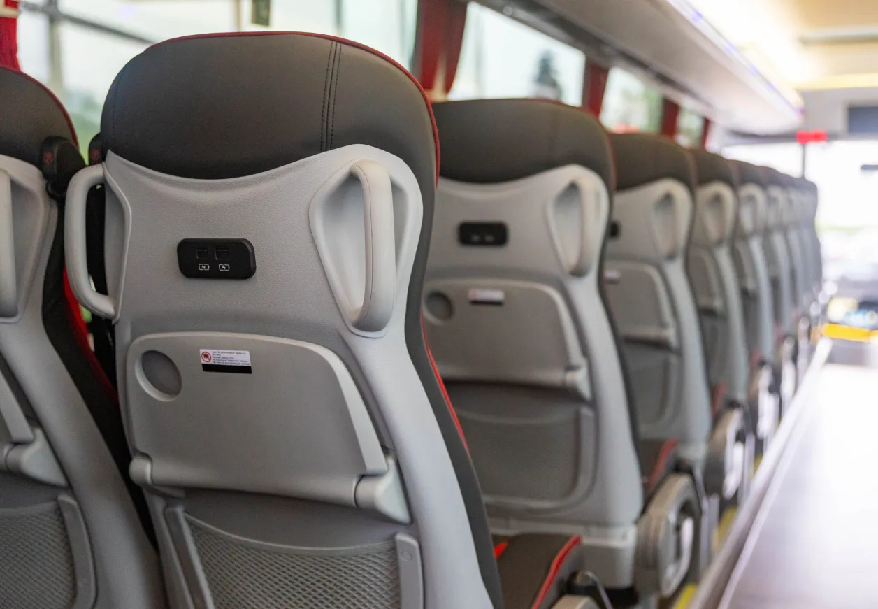 Sitzreihen mit grauen Polstern und roten Akzenten im Elektro-Reisebus