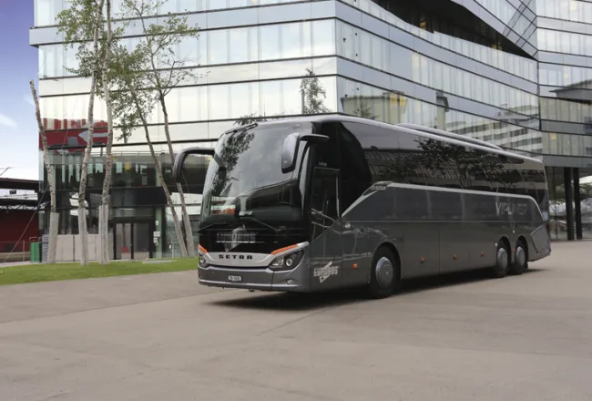 A dark grey VIPLINER parked in front of a glass building