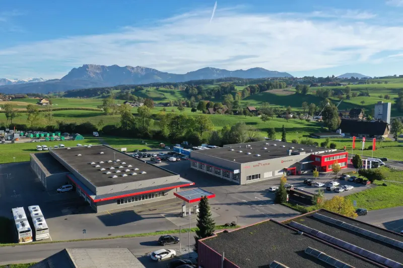 Aerial view of the EUROBUS Central Switzerland location in Ruswil, with hills and mountains behind