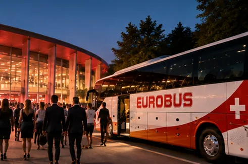 In the evening, guests walk from a EUROBUS coach to an illuminated hall