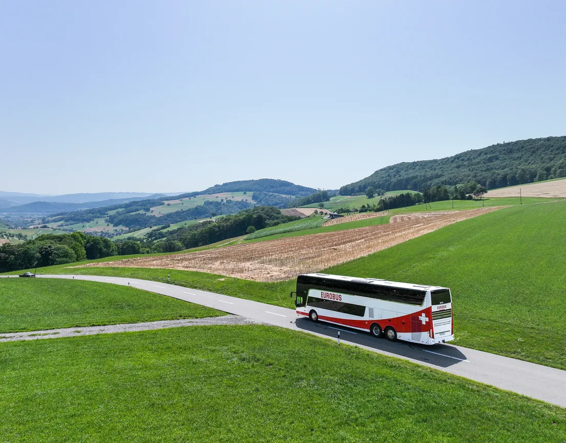 A EUROBUS coach on a country road between green hills