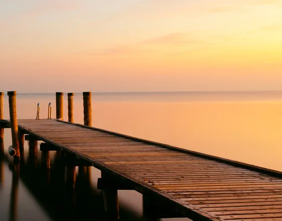 Ponton en bois sur un lac paisible dans la lumière du soir