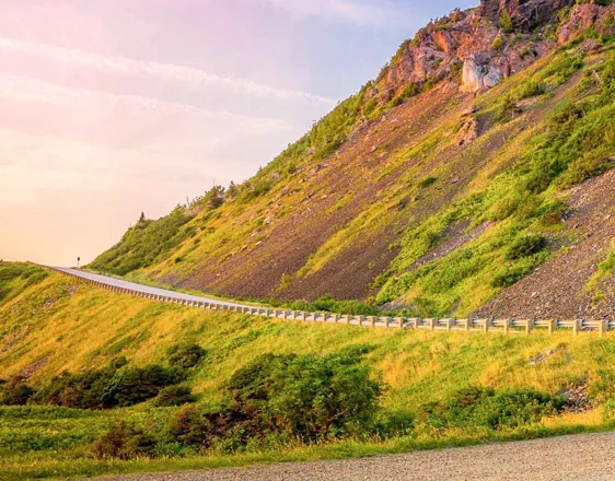 Winding coastal road on a hillside above the sea in the evening light